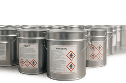 photographic Photorealistic closeup of multiple sealed paint tins arranged neatly with warning hazard labels visible Set against a clean warehouse bac-1